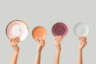 Açık arkaplanda boş tabakları tutan eller