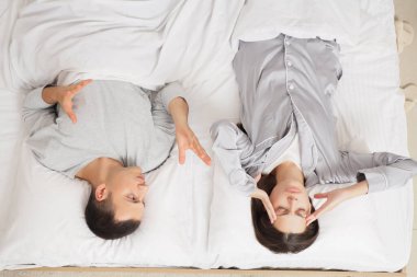 Yatakta kavga eden genç bir çift.