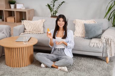 Evde B vitamini haplı genç bir kadın var.