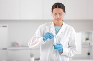 Araştırma laboratuarında su kalitesini inceleyen mutlu genç bilim kadını.
