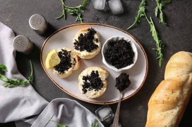 Koyu arkaplanda lezzetli siyah havyarlı ekmek dilimleri.