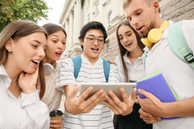 Üniversite yakınlarında tablet bilgisayar kullanan bir grup öğrenci