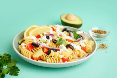 Turkuaz arka planda geleneksel makarna salatası ile tabak