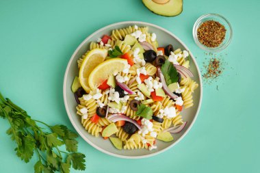 Turkuaz arka planda geleneksel makarna salatası ile tabak