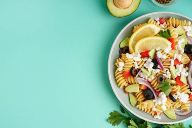 Turkuaz arka planda geleneksel makarna salatası ile tabak