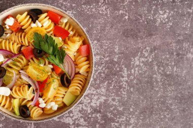 Arkaplanda geleneksel makarna salatası olan tabak.