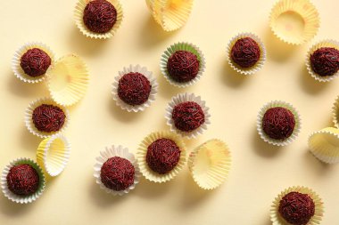 Lezzetli çikolatalı mantarlar ve bej arka planda kağıt bardaklar.