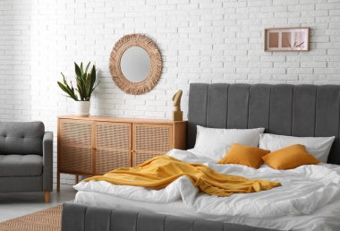 Yatak odasının içi rahat yatak odası, çekmeceler ve ayna dolu.