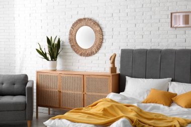 Yatak odasının içi rahat yatak odası, çekmeceler ve ayna dolu.