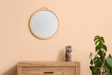 Taş kadın vücudu ve bej duvarda ayna olan çekmeceler.