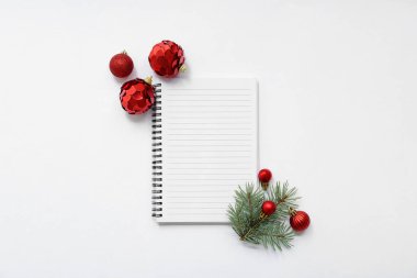 Noel topları ve beyaz arkaplanda köknar ağacı dalları olan defter