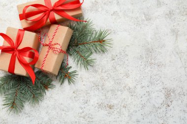 Beyaz grunge arka planında köknar ağacı dalları olan Noel hediye kutuları