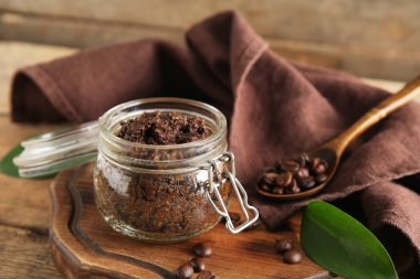 Tepsiyle kompozisyon, kavanoza konan kahve bedeni ve ahşap arka planda peçete.