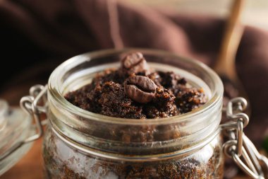 Kahverengi arka planda kahve kaplı kavanoz, yakın plan.