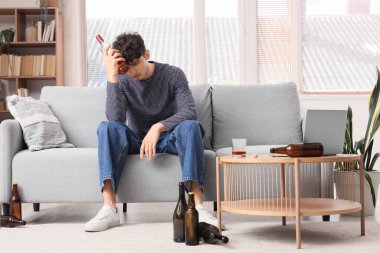 Evdeki sarhoş genç adam. Alkolizm kavramı