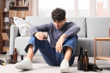 Evdeki sarhoş genç adam. Alkolizm kavramı