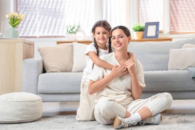 Annesine kucak açan küçük kızı evde yerde yatıyor. Uluslararası Sarılma Günü