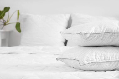 Yatak odasındaki yastıklar ve beyaz battaniye