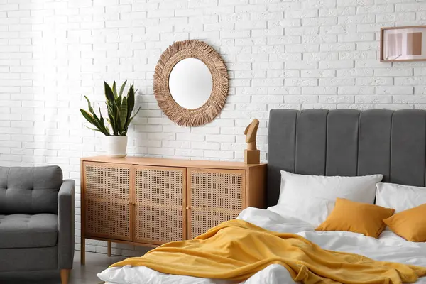 Yatak odasının içi rahat yatak odası, çekmeceler ve ayna dolu.