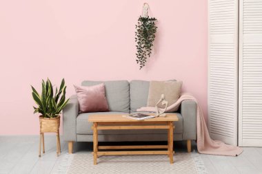 Oturma odasındaki kanepe, masa ve katlanan ekran.