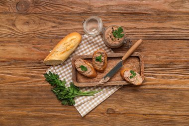 Ahşap zemin üzerinde tost, maydanoz ve bıçaklı lezzetli börek kavanozu.