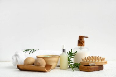 Kozmetik ürünleri, spa aksesuarları ve hafif arka planda bitki dalları ile kompozisyon