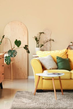 Rahat sarı kanepesi ve sehpası olan şık bir oda.