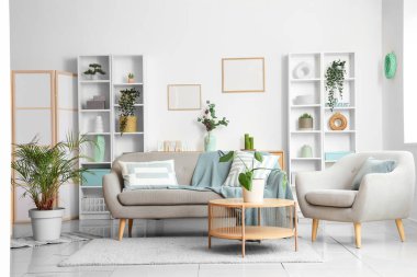 Konforlu kanepe, koltuk ve oturma odasının iç tarafındaki çiçekli kahve masası.