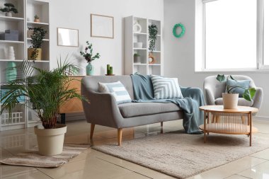 Konforlu kanepe, koltuk ve oturma odasının iç tarafındaki çiçekli kahve masası.