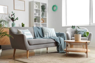 Konforlu kanepe, koltuk ve oturma odasının iç tarafındaki çiçekli kahve masası.