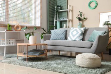 Oturma odasının içinde kanepe, kahve masası ve bitkiler var.