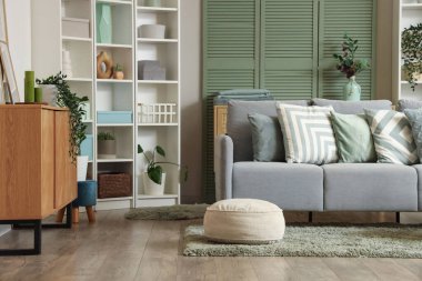 Konforlu kanepe, çekmece sandığı ve oturma odasının içindeki raf ünitesi.