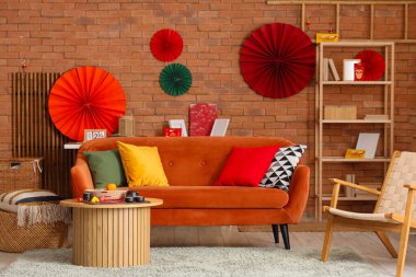 Çin Yeni Yıl kutlamaları için kırmızı kanepe, masa ve dekorla oturma odasının içinde.