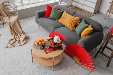 Çin Yeni Yıl kutlamaları için kanepe, masa ve dekorla aydınlık oturma odasının içinde.