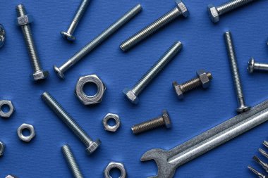 Mavi arka planda cıvatalı, fındıklı ve ingiliz anahtarlı kompozisyon