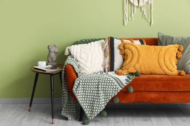 Oturma odasının iç tarafında minderleri ve kahve masası olan rahat bir kanepe.