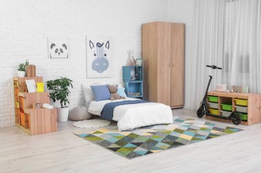 Yataklı, raflı ve scooterlı çocuk odasının içi.