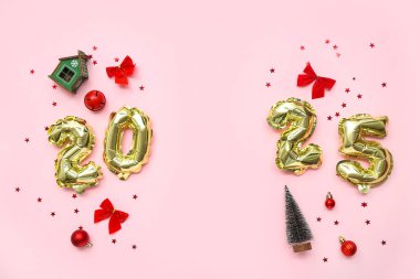 2025 yılbaşı süsleri ve pembe arka planda konfetileri olan folyo balonlardan yapılmış.