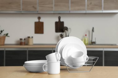 Mutfaktaki ahşap masada temiz tabaklar var.