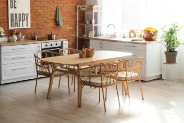 Pencerenin yanında beyaz kasımpatı olan mutfağın içi.