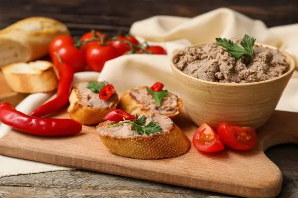 Kızarmış ekmek, bir kase lezzetli börek, maydanoz, biber ve domatesli ahşap zemin.