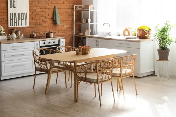 Pencerenin yanında beyaz kasımpatı olan mutfağın içi.