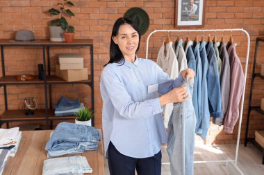 Erkek giyim mağazasında kot pantolon giyen kadın satıcı.