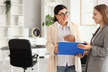 İş arkadaşıyla birlikte çalışan hamile bir iş kadını.