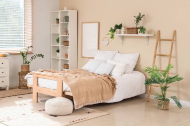 İçinde raf ünitesi, merdiven ve bitkiler olan rahat bir yatak odası.