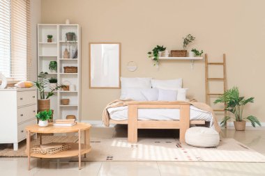 İçinde raf ünitesi, merdiven ve bitkiler olan rahat bir yatak odası.