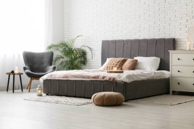 Modern yatak odasının içi yanan mumlarla dolu.