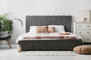 Modern yatak odasının içi yanan mumlarla dolu.