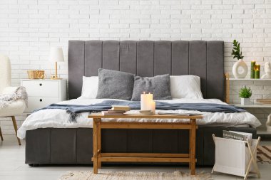 Yatak odasının içinde kitaplar ve yanan mumlar var.