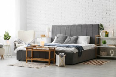 Yatak odasının içinde kitaplar ve yanan mumlar var.